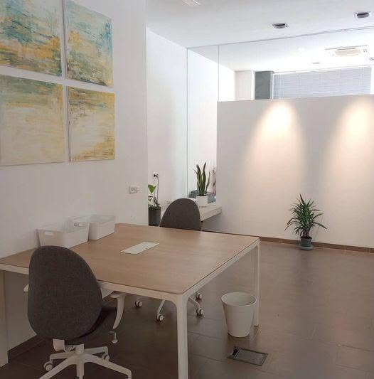 Shared desks and adjustable office chairs inside North Mallorca Coworking